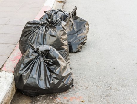 Clean residential street in Enoggera with trash collection truck